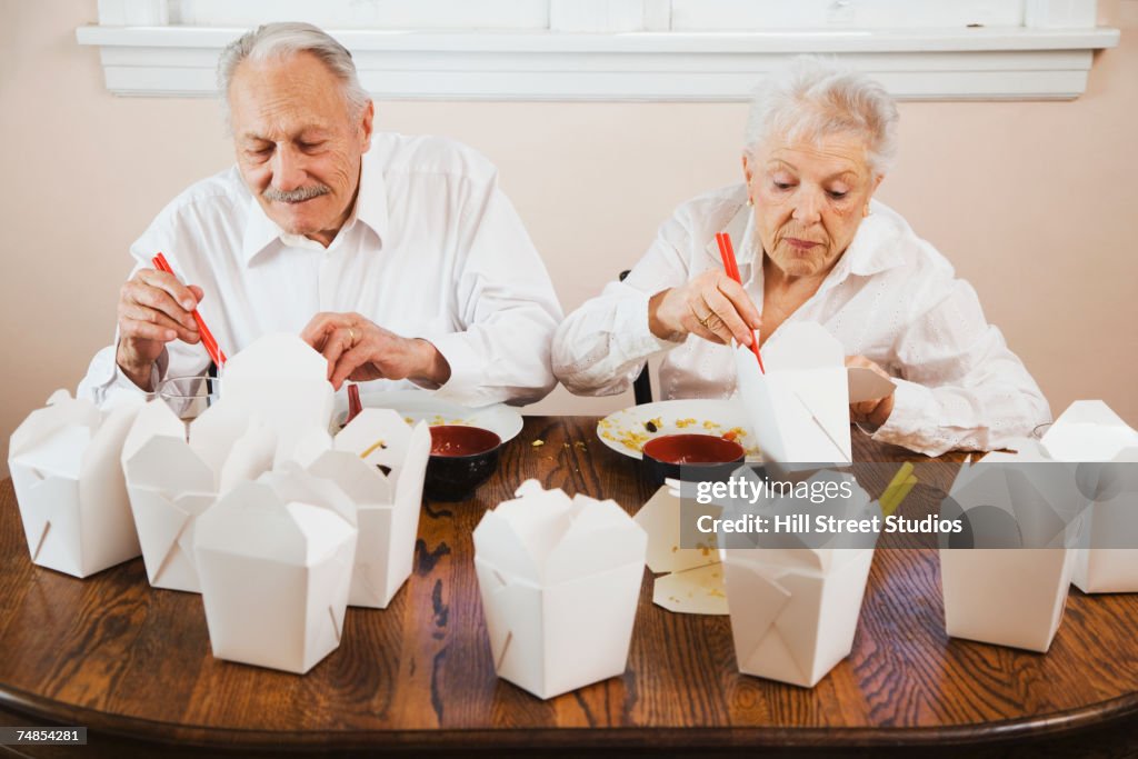 Senior couple eating Chinese takeout food