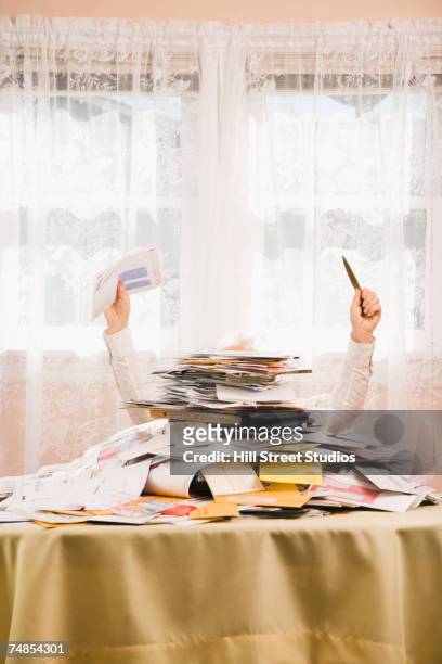 senior man behind pile of bills - abrecartas fotografías e imágenes de stock