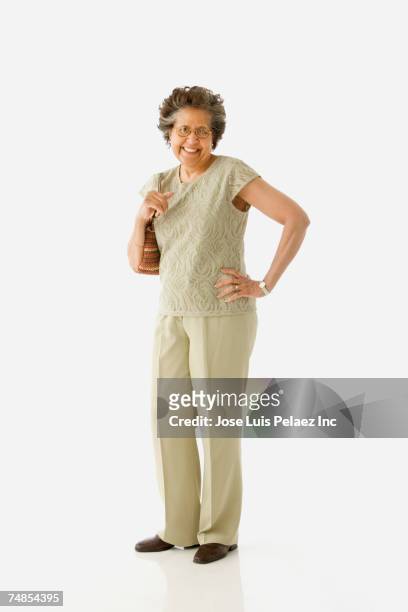 studio shot of senior hispanic woman with purse - ages 65 70 stock pictures, royalty-free photos & images
