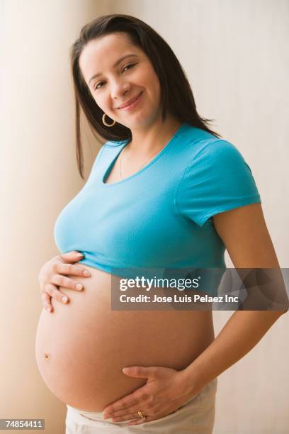 Pregnant Hispanic Woman Smiling With Bare Belly High-Res Stock