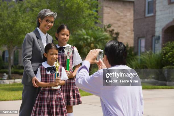 father taking photograph of family with trophies - school award stock pictures, royalty-free photos & images