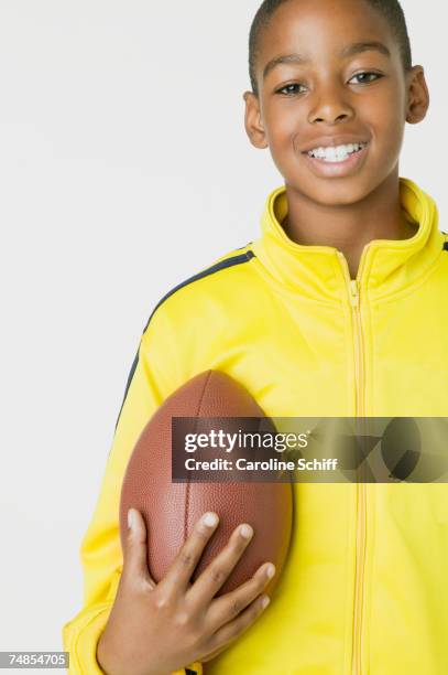 african boy holding football - american football ball studio stock pictures, royalty-free photos & images