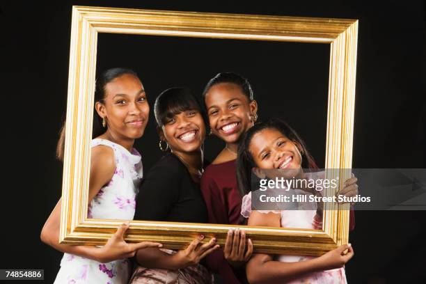 african sisters posing in picture frame - family picture frame stockfoto's en -beelden