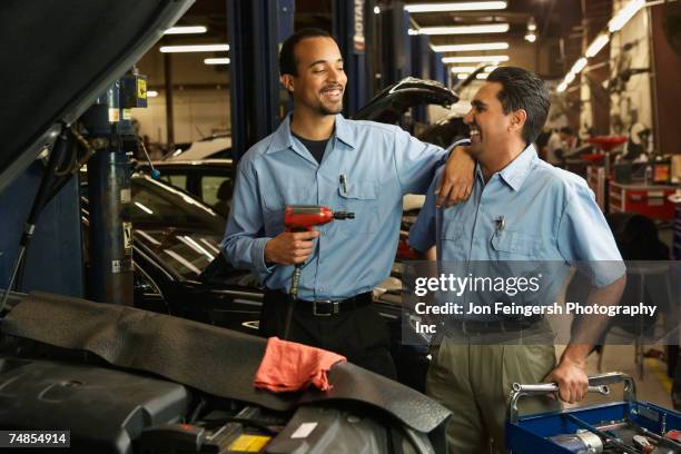 multi-ethnic male auto mechanics in shop - multi tool stock-fotos und bilder