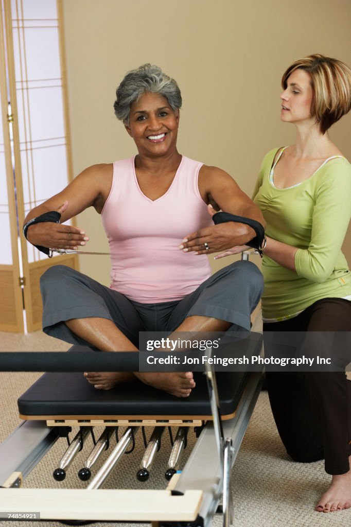 African woman exercising with personal trainer