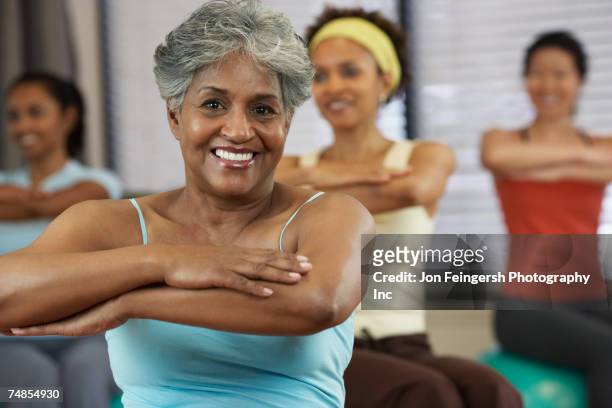 multi-ethnic women in exercise class - 50 59 years stock pictures, royalty-free photos & images