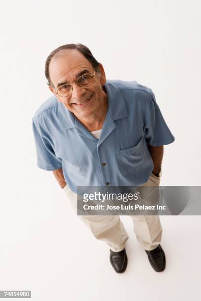 senior hispanic man with hands in pockets - elevated view of person on white background stock pictures, royalty-free photos & images