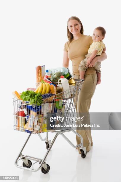 russian mother holding baby and grocery shopping - mujeres de mediana edad fotografías e imágenes de stock