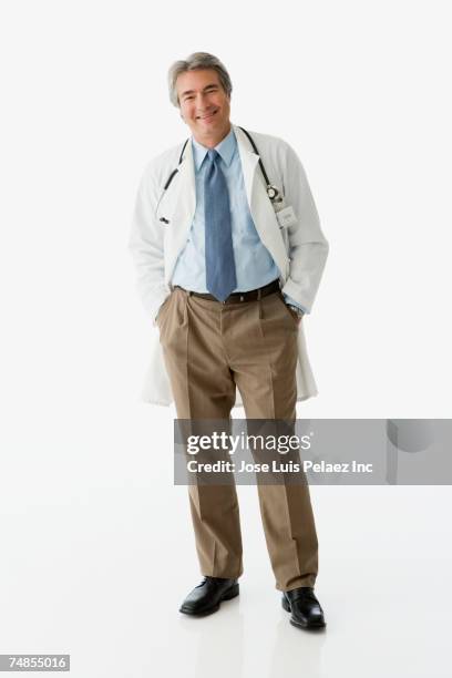 hispanic male doctor with hands in pockets - cuban doctors stock-fotos und bilder