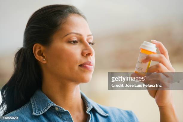 hispanic woman reading medication - prescription medicine stock pictures, royalty-free photos & images