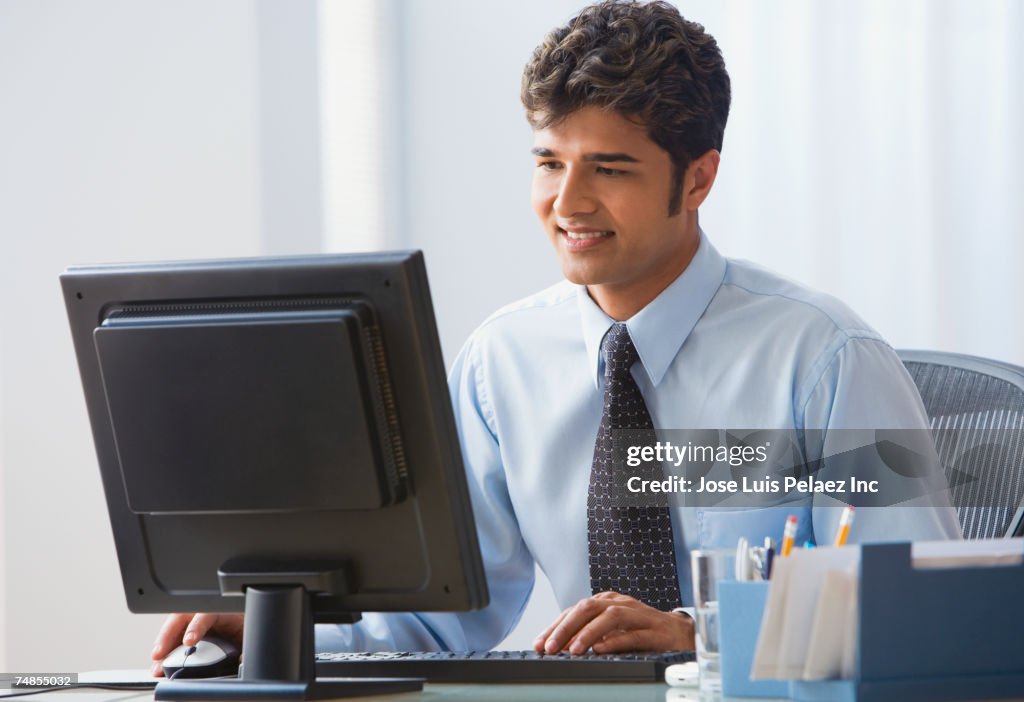 Indian businessman typing on computer