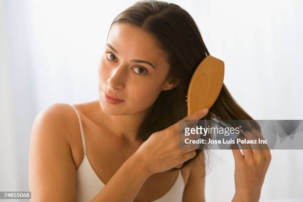 woman brushing hair - cepillar el cabello fotografías e imágenes de stock