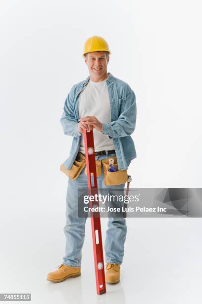 male construction worker holding level - builder standing isolated stock-fotos und bilder