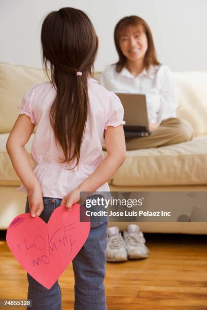 asian girl surprising mother with paper cut out heart - giving back bildbanksfoton och bilder