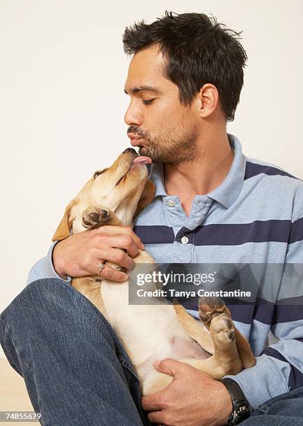 mixed race man kissing dog - chien et maitre photos et images de collection