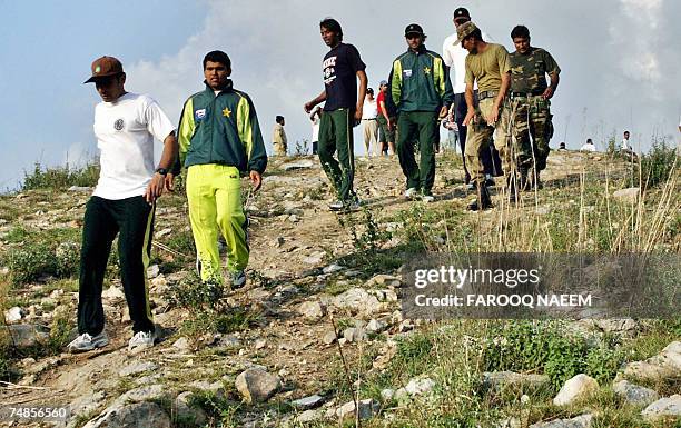 In this picture taken 21 June 2007, Pakistani cricketers Misbah-ul-Haq , Kamran Akmal , Mohammad Asif and Mohammad Hafiz climb down a mountain with...