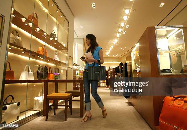 Woman looks at goods at an outlet of the French fashion brand Hermes in Shanghai, 19 June 2007. The luxury icon opened a new store to mark its 10th...