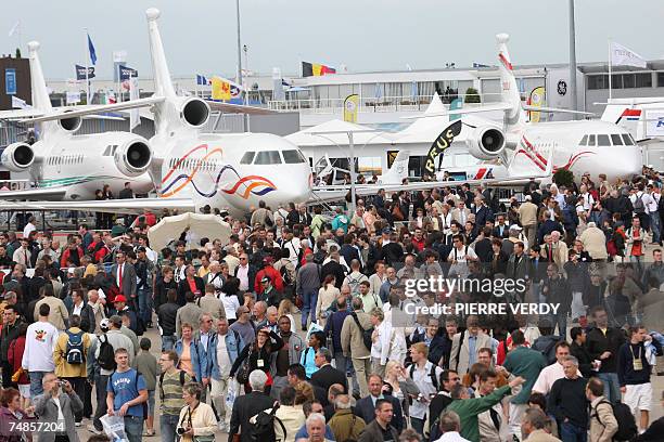 Visitors walk in front of Dassault's Falcon jets at Le Bourget airport during the 47th Paris International air show 22 June 2007. The Paris show...