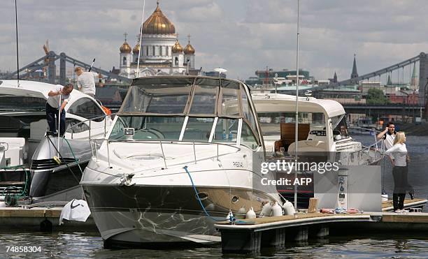 Moscow, RUSSIAN FEDERATION: Owners of yachts clean their vessels at a berth during the first day of the third Moscow Yacht Fetsival in Gorky park in...