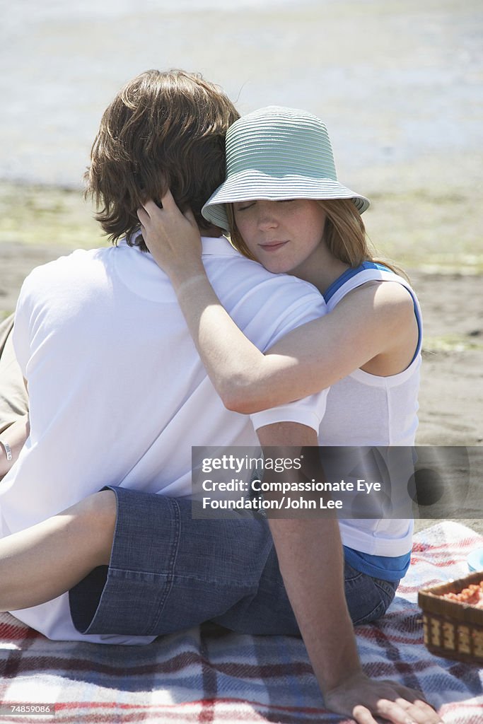 Young couple embracing during picnic at seashore