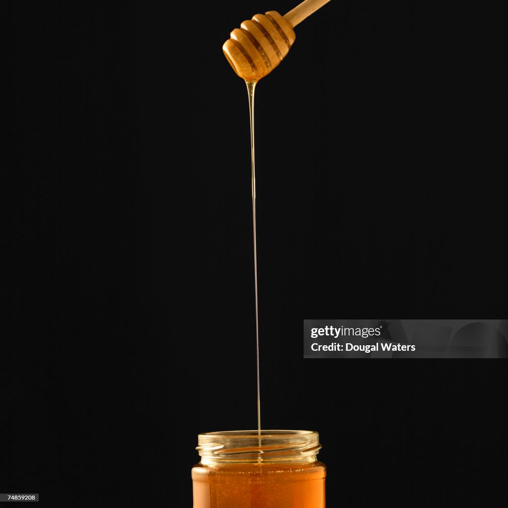 Jar of honey and stirrer