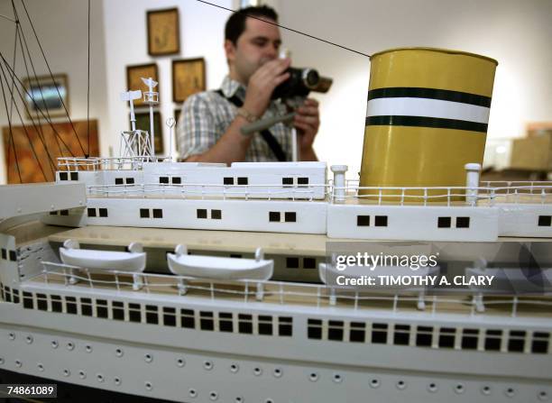 New York, UNITED STATES: A member of the press photographs a model of the S.S. Nieuw Amsterdam during a press preview 22 June 2007 for the...