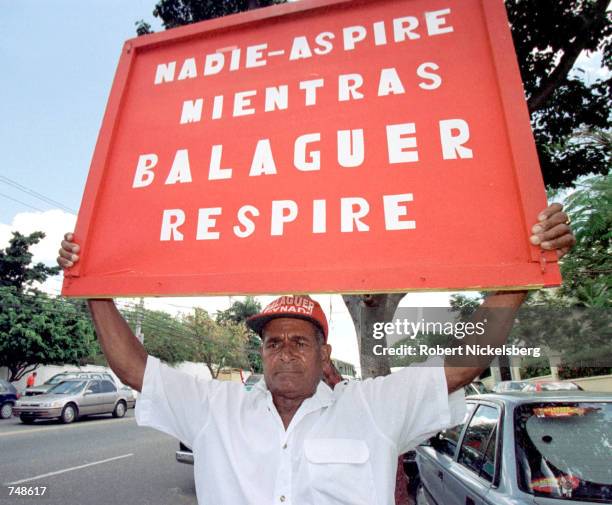 Dominican party loyalist of Joaquin Balaguer stands May 8, 2000 outside the house of veteran political leader in Santo Domingo, Dominican Republic....
