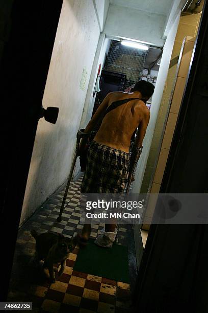 Mr Chan, cage dweller walks back to his home on June 20, 2007 in Hong Kong, China. The poorest of Hong Kong's citizens live in cage homes, steel mesh...