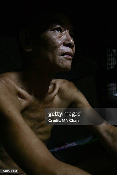 Mr Jau, a cage dweller sits inside a cage on June 20, 2007 in Hong Kong, China. The poorest of Hong Kong's citizens live in cage homes, steel mesh...