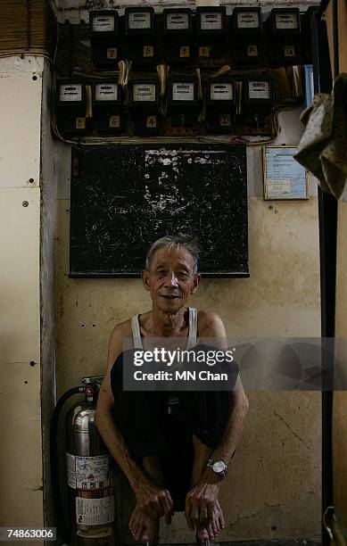 Mr Leung, a cage dweller sits in front of electricity meters on June 20, 2007 in Hong Kong, China. The poorest of Hong Kong's citizens live in cage...