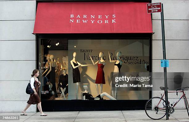 Woman walks past a Barneys New York store window June 22, 2007 in New York City. Jones Apparel Group Inc. Plans to sell Barneys New York to the Dubai...