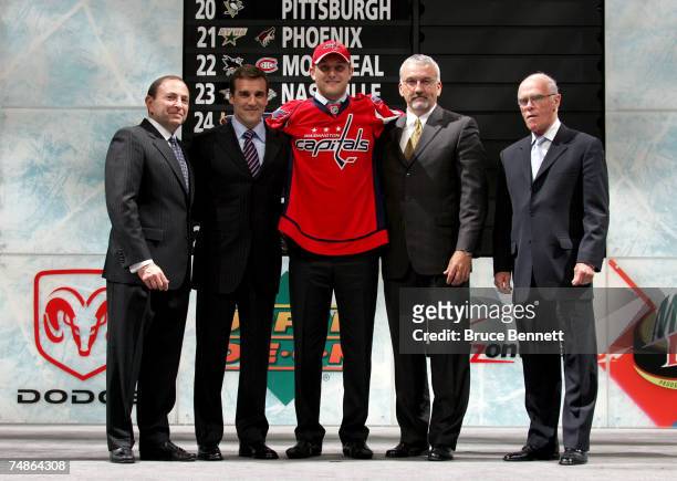 Fifth overall pick Karl Alzner of the Washington Capitals poses with team personnel after being drafted in the first round of the 2007 NHL Entry...