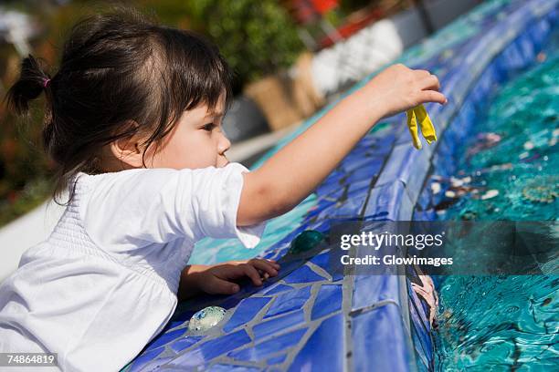 side profile of a girl holding a balloon at the poolside - free mosaic patterns stock-fotos und bilder