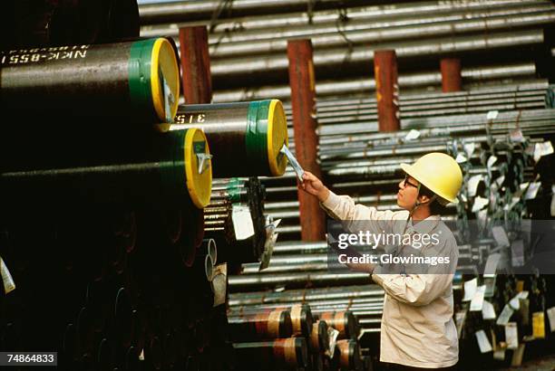 side profile of a male worker inspecting at a steel mill, kawasaki, honshu, japan - 工場　日本人 ストックフォトと画像