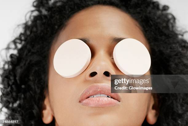 close-up of a young woman with powder puffs over her eyes - powder puff stock pictures, royalty-free photos & images