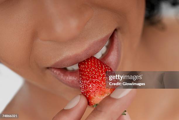 close-up of a young woman eating a strawberry - juicy lips stock pictures, royalty-free photos & images