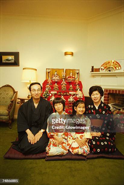 mid adult couple sitting with their two daughters in front of dolls at a traditional doll festival, hinamatsuri, tokyo prefecture, japan - girls day stock pictures, royalty-free photos & images