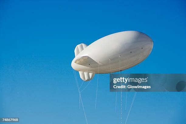 low angle view of a blimp in the sky - blimp stock-fotos und bilder