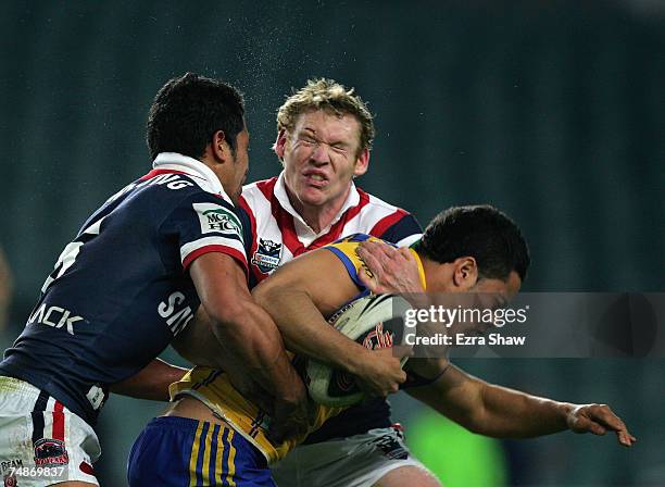 Setaimata Sa and Joel Monaghan of the Roosters collide heads while they tackled Jarryd Hayne of the Eels during the round 15 NRL match between the...