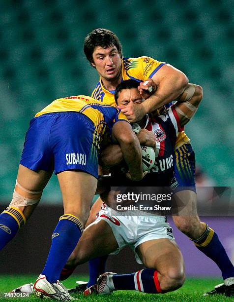 Sam Perrett of the Roosters is tackled by the Eels defence during the round 15 NRL match between the Sydney Roosters and the Parramatta Eels at...