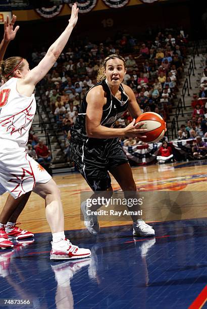 Becky Hammon of the San Antonio Silver Stars shoots against Jamie Carey of the Connecticut Sun on June 23, 2007 at Mohegan Sun Arena in Uncasville,...