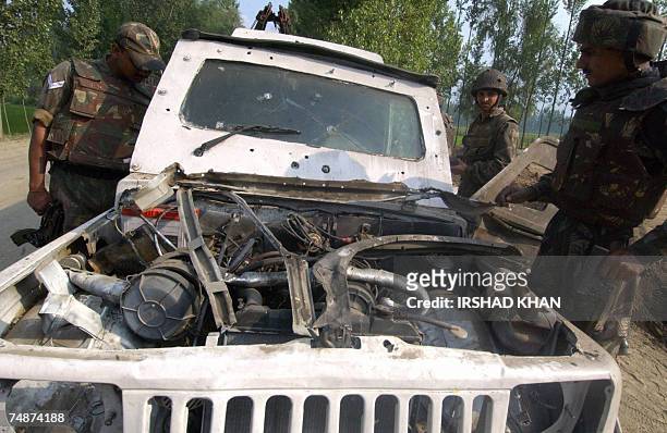 Indian Army soldiers examine a police armored vehicle damaged in an explosion on the outskirts of Srinagar, 24 June 2007. At least ten personnel of...