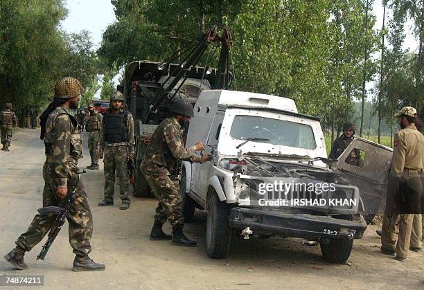 Indian Army soldiers examine a police armored vehicle damaged in an explosion on the outskirts of Srinagar, 24 June 2007. At least ten personnel of...