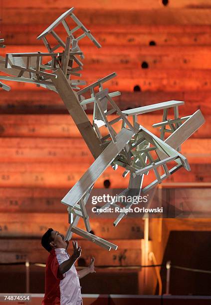 Chinese performer Guozhi Guo balances a stack of wooden trestle tables on his chin during the live broadcast of "Wetten dass..?" at the Coliseo...