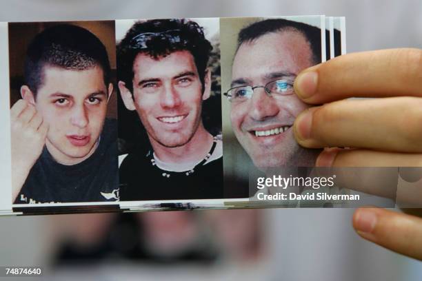 An Israeli distributes bumper stickers with the photos of the three captured Israeli soldiers Gilad Shalit , Eldad Regev and Ehud Goldwasser during a...