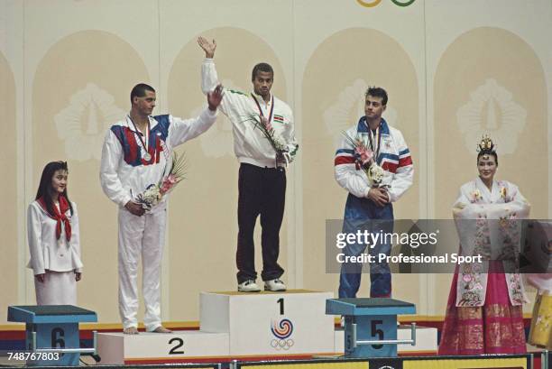 View of the winners of the Men's 100 metres butterfly swimming event with, from left, silver medallist Matt Biondi of the United States, gold...