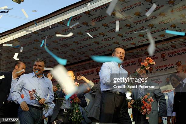 Prime Minister Recep Tayyip Erdogan and Foreign Minister Abdullah Gul throw flowers before speaking to thousands of flag-waving Turks who jammed into...