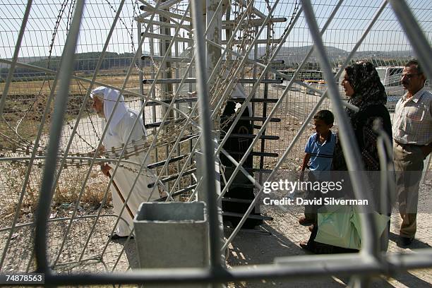 Palestinians pass through the Israeli army checkpoint June 25, 2007 at Hawarra on the outskirts of the West Bank city of Nablus. Israeli Prime...