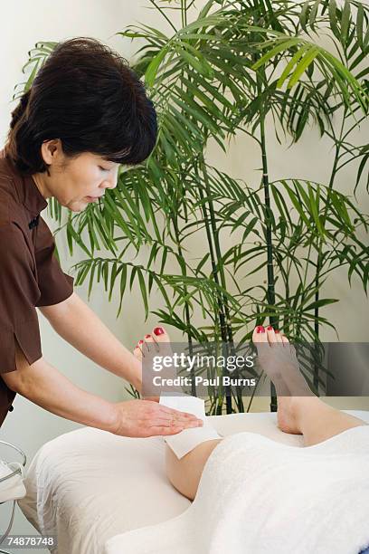 mature woman having legs waxed - ceretta per le gambe foto e immagini stock