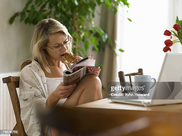 young woman having breakfast while reading magazine - magazines on table bildbanksfoton och bilder